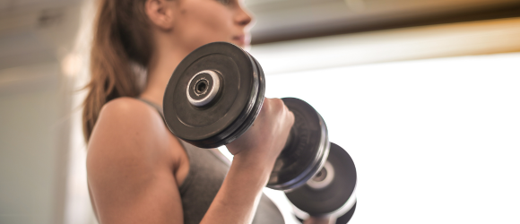 femme soulevant des haltères pour faire de la musculation pour perdre du poids