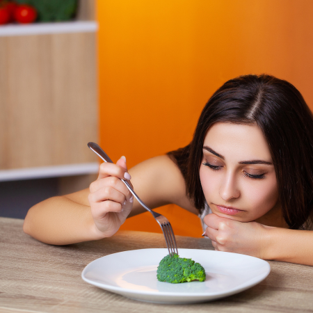femme frustrée par un régime trop strict qui interdit des aliments et n'en autorise que certains pour perdre du poids